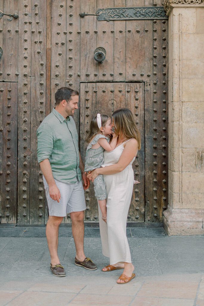 Family of four wearing pastel linen outfits near Valencia Cathedral during an Old Town photoshoot