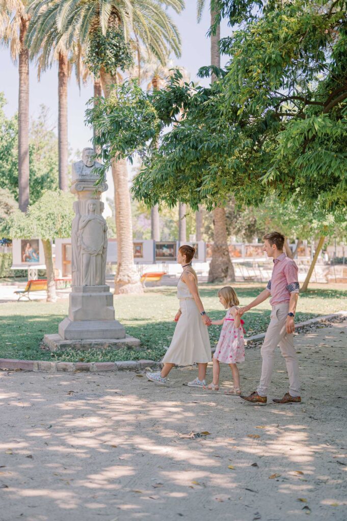 Family enjoying a relaxed photoshoot surrounded by greenery in Viveros Gardens in Valencia
